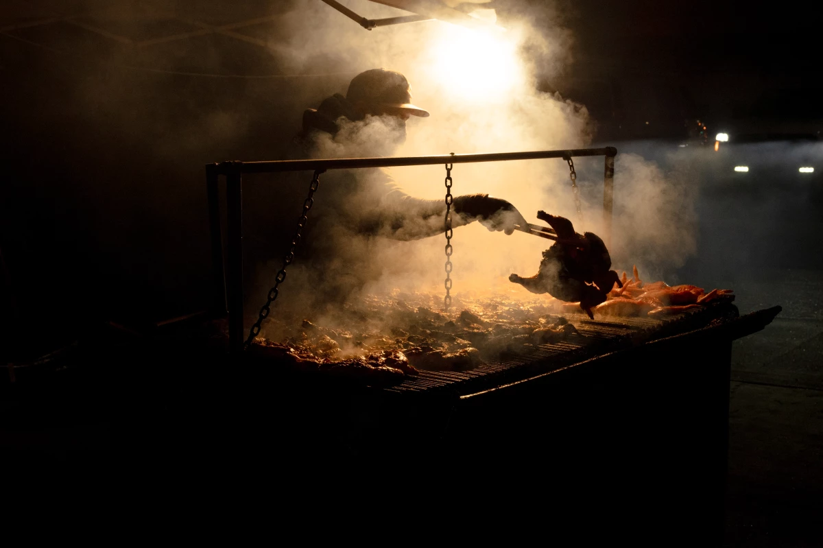 A vendor grills chicken roadside for customers in Fremont, Neb. He says the majority of his customers are from the surrounding Latino community.