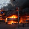 A man carries a box from a burning trade center after a Russian strike on Kyiv, Ukraine, on Sunday, May 24, 2026.