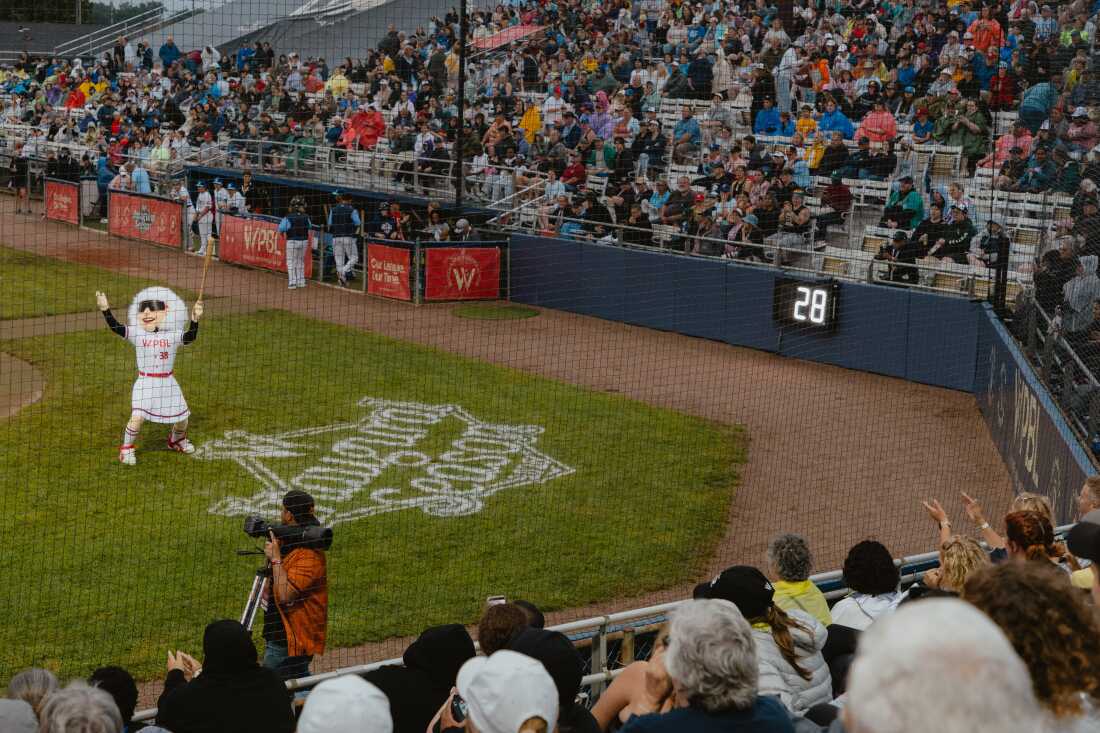 Maybelle the Mascot, designed in honor of veteran baseball player Maybelle Blair, entertains the crowd in between innings at the opening game of the Women's Pro Baseball League. Springfield, IL, August 1, 2026.