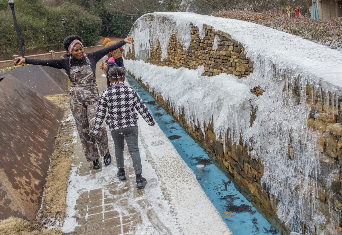 Macon, Georgia: Earnestine Wilson and her daughter Anayla, 7, enjoy the early snowfall on Jan. 21. 'She's having a ball!' her mother said.