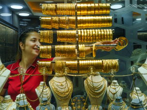 A female jeweler takes gold bracelets from a display case at the Grand Bazaar to show them to customers in Istanbul, Turkey, on Aug. 20, 2026.