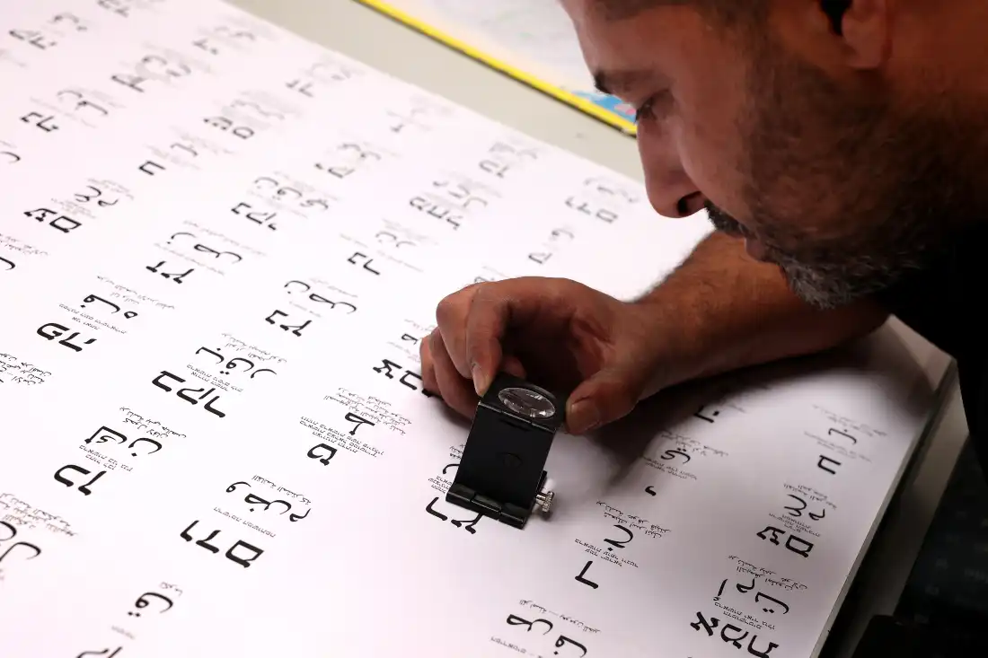 A worker uses a loupe to examine ballots at a printing factory, ahead of the Israeli legislative elections in Kiryat Gat, southern Israel, on October 8, 2026.