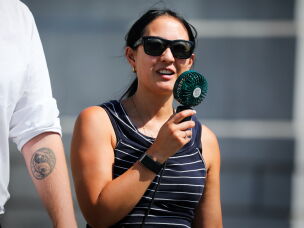 A person uses a fan to cool down in Trafalgar Square during the fifth heatwave of the season on Aug. 13, 2026, in London.