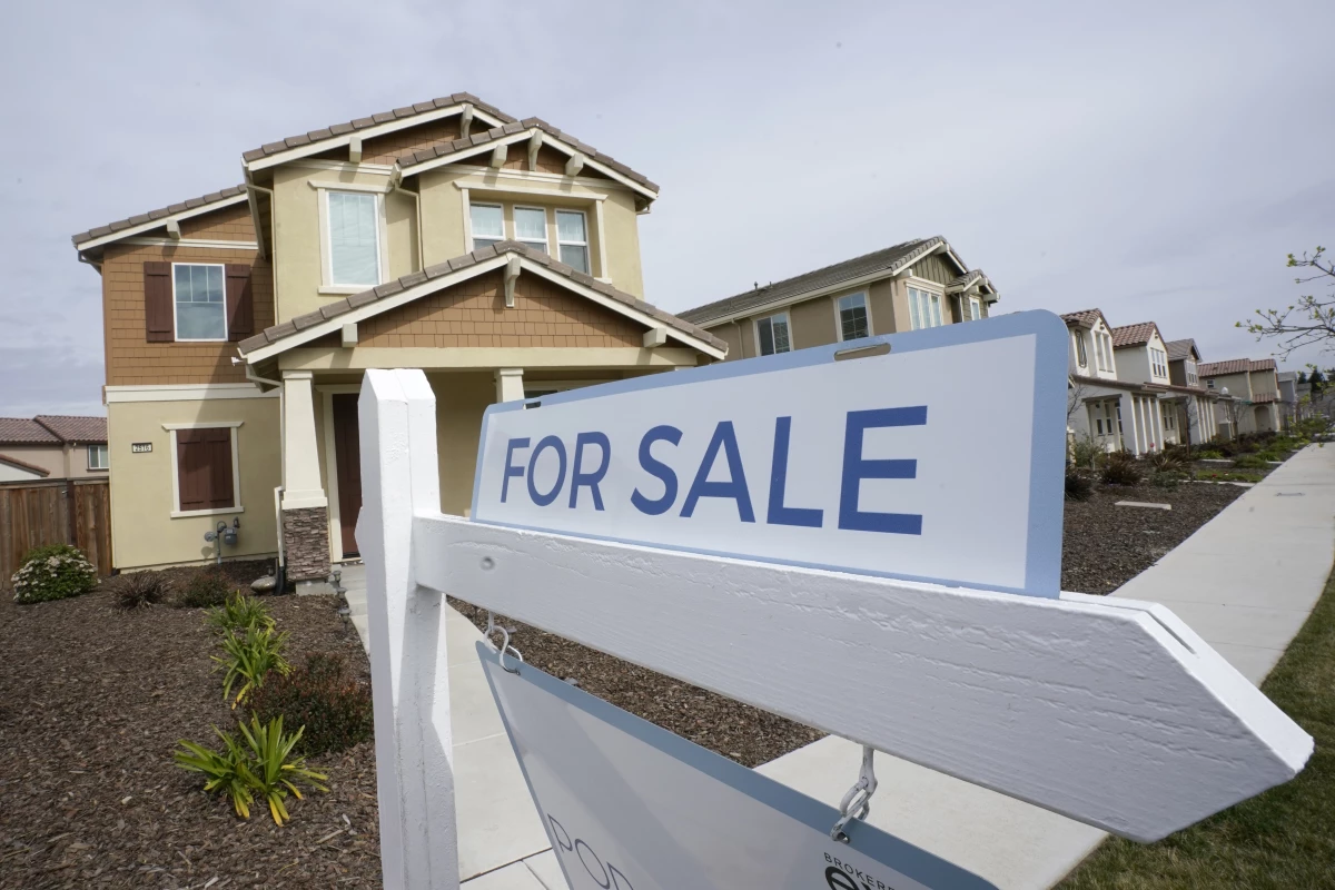 A for sale sign is posted in front of a home in Sacramento, Calif., in 2022.