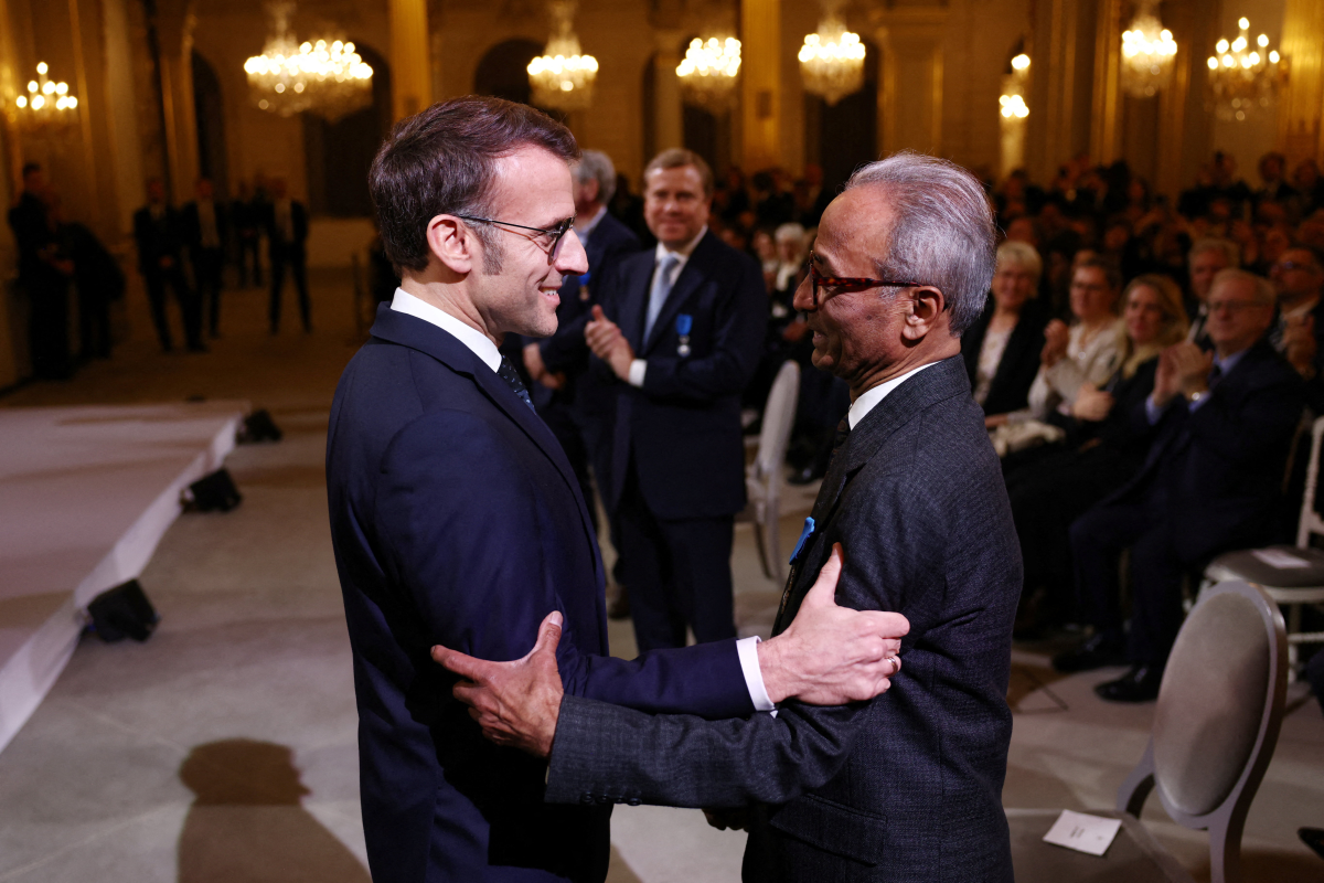 French President Emmanuel Macron awards the Chevalier of the French National Order of Merit to Ali Akbar at the Elysee Palace in Paris on Jan. 28, 2026. Akbar, an immigrant from Pakistan, has been selling newspapers around Saint-Germain-des-Pres in the French capital for 50 years.