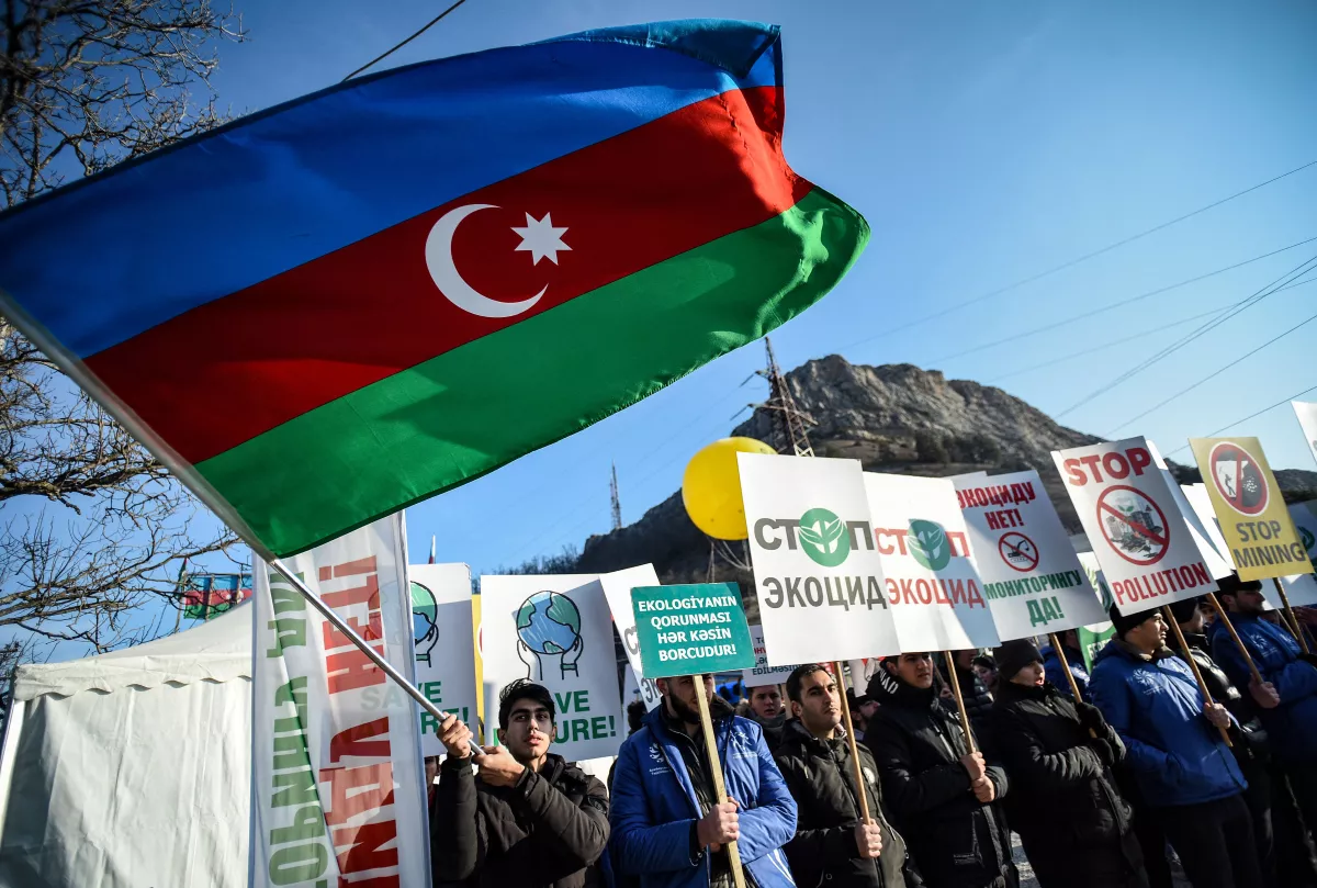 An Azerbaijani environmental activist waves a national flag during a protest against what they claim is illegal mining at the Lachin corridor, the only land link between the Armenian-populated breakaway Nagorno-Karabakh region and Armenia.