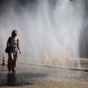 People try to cool off at Rudolfplatz Square during the 'Cooling Cologne' initiative, where chilled groundwater was dispersed through fine mist sprays connected to fire hoses in Cologne, Germany on July 29, 2026.