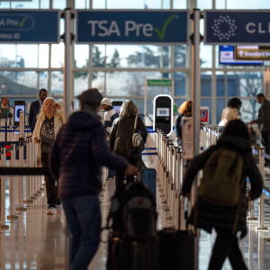 FILE - Travelers walk through a TSA security checkpoint at Reagan National Airport in Washington, March 24, 2026.