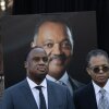 Family members stand in front of a portrait of the Rev. Jesse Jackson.
