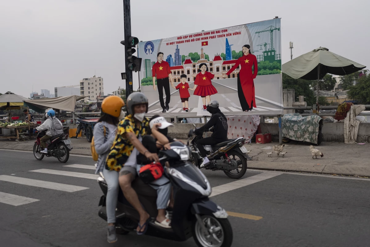 A billboard campaigning for each family to have two children hangs above a street in Ho Chi Minh City, Vietnam, Jan. 14, 2024.