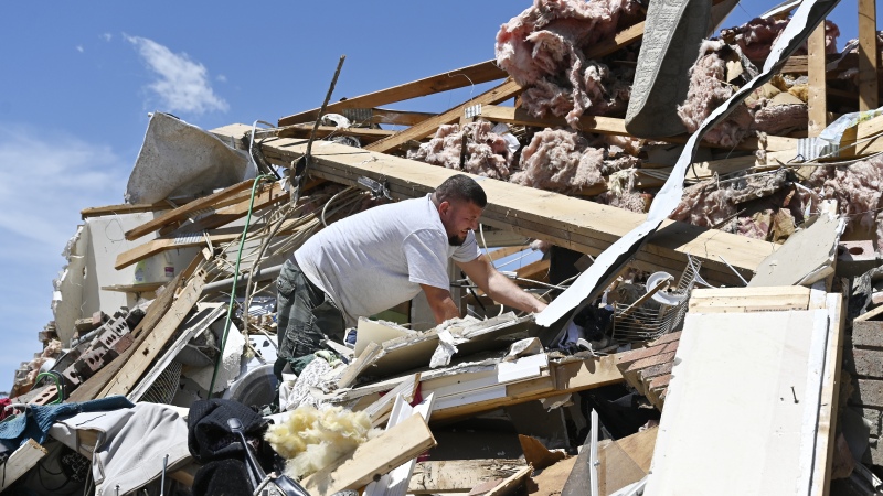 Anthony Broughton digs through the debris of his destroyed home following a severe storm in London, Ky., on Saturday.