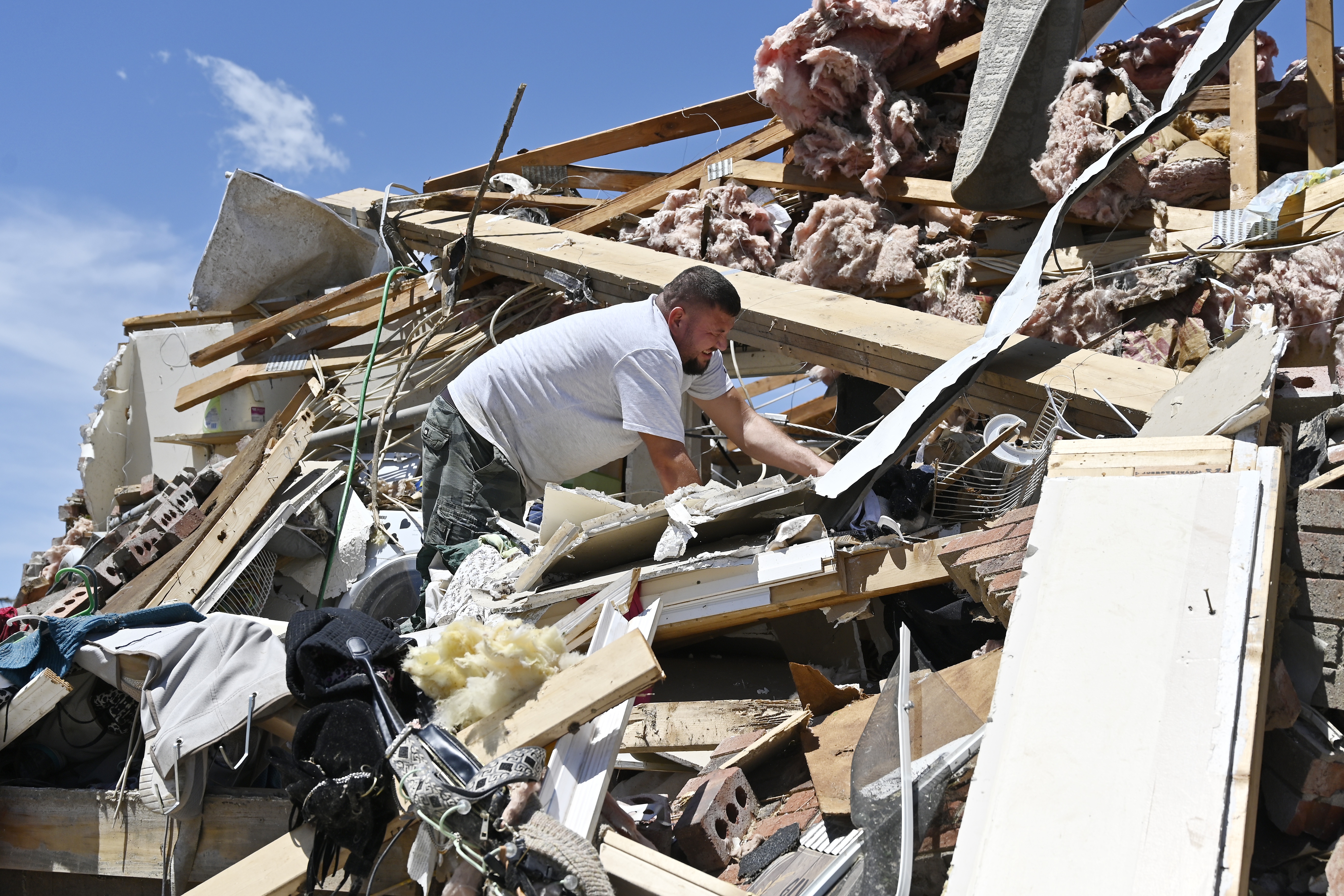 Anthony Broughton digs through the debris of his destroyed home following a severe storm in London, Ky., on Saturday.