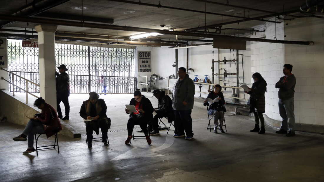Hospitality workers wait in line to apply for unemployment benefits at the outset of the COVID-19 pandemic in March 2020.