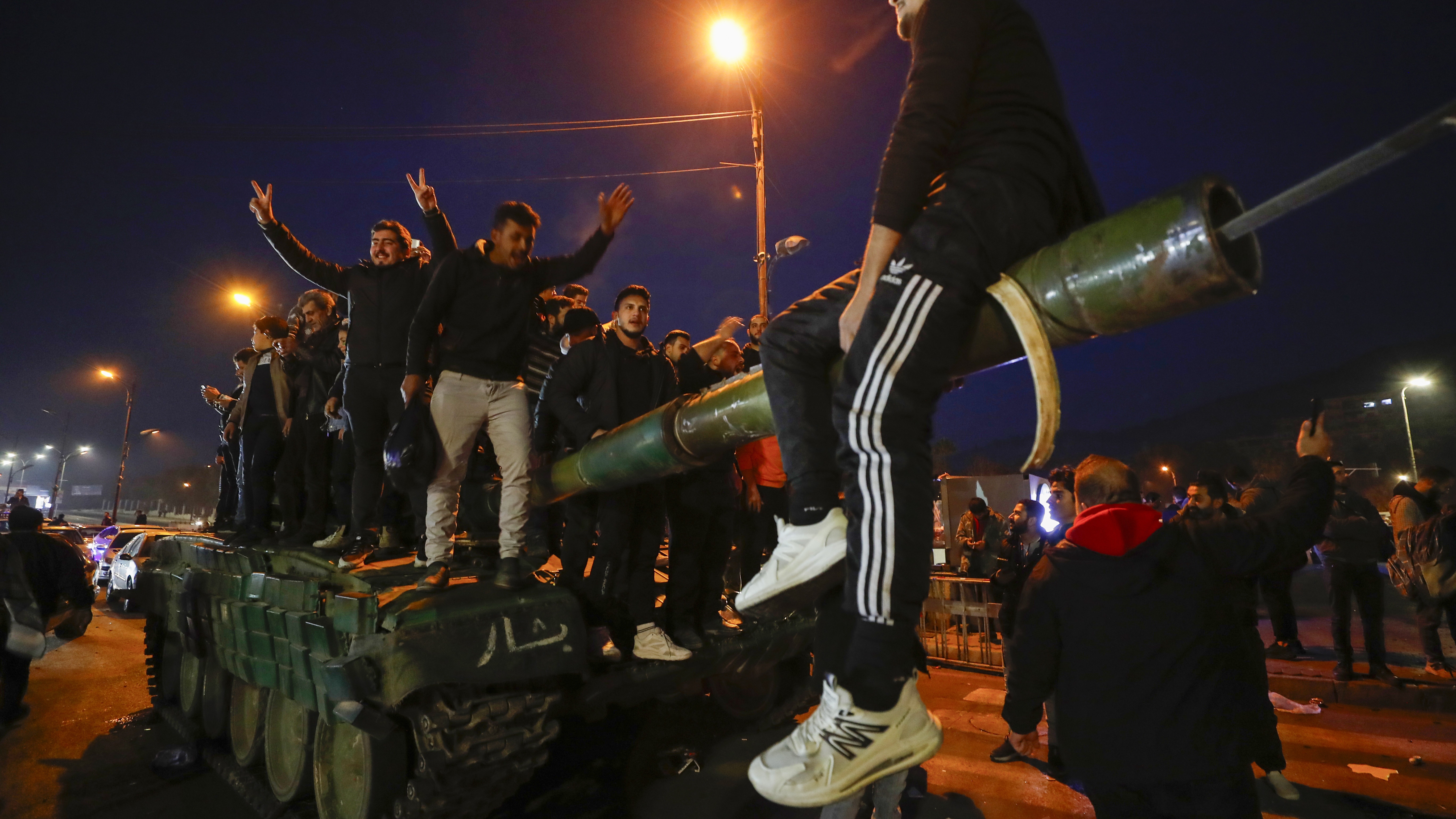 Syrians celebrate the arrival of opposition fighters in Damascus, Syria, on Sunday.