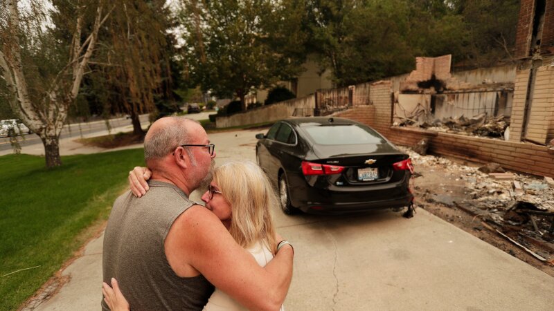 Allen Sather and his wife Kimberley embrace at the duplex they rent on W. Indian Trail Rd. after it burned in a wildfire in Spokane, Wash., Sunday, Aug. 2, 2026.