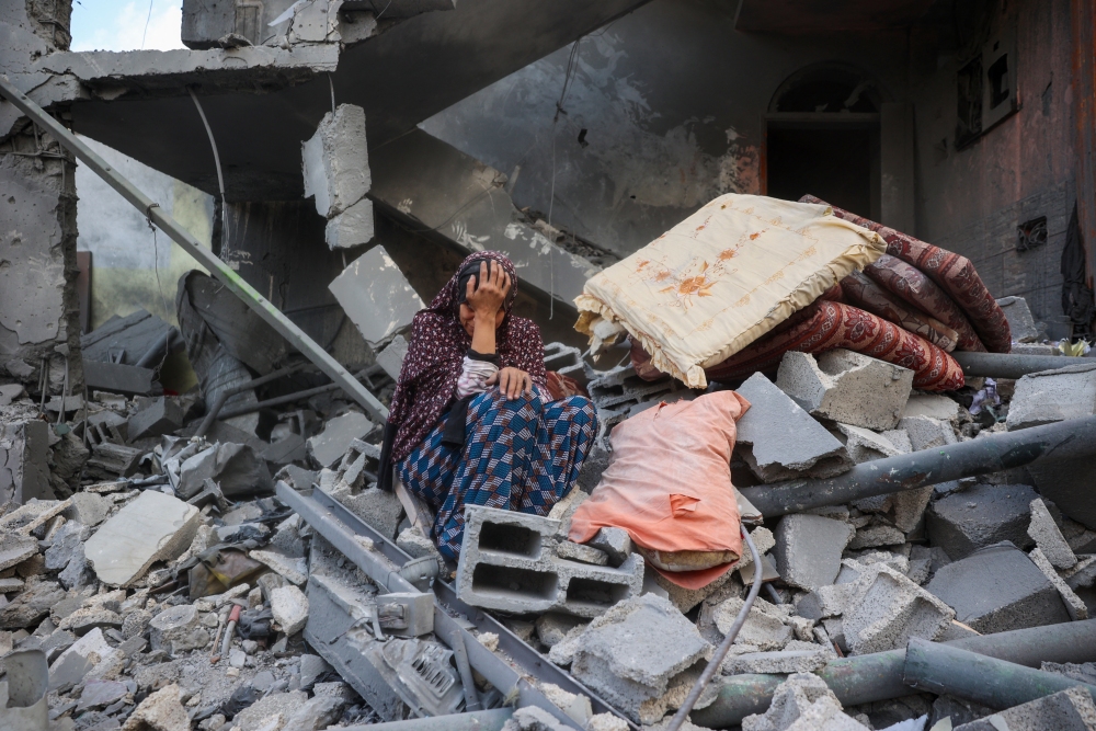 A woman cries while sitting on the rubble of her house, destroyed in an Israeli strike, in the Nuseirat refugee camp in central Gaza Strip on Tuesday. (AFP via Getty Images)