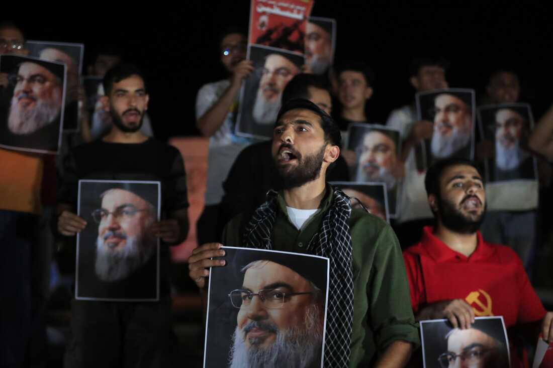 Lebanese and Palestinian men hold portraits of Hezbollah leader Sayyed Hassan Nasrallah during a protest in the southern port city of Sidon, Lebanon, Saturday, Sep. 28, 2024.