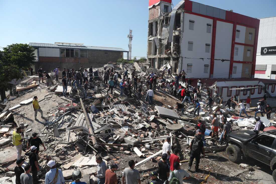 Residents and rescue workers search through the rubble of a collapsed building after an earthquake struck Cali, Colombia, Monday, Aug. 10, 2026.