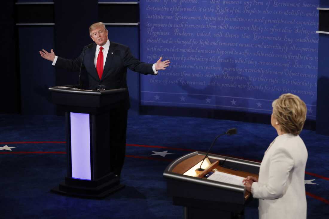 Republican presidential nominee Donald Trump speaks as Democratic presidential nominee Hillary Clinton (R) looks on during the final presidential debate at the Thomas & Mack Center on the campus of the University of Las Vegas in Las Vegas, Nevada on October 19, 2016.