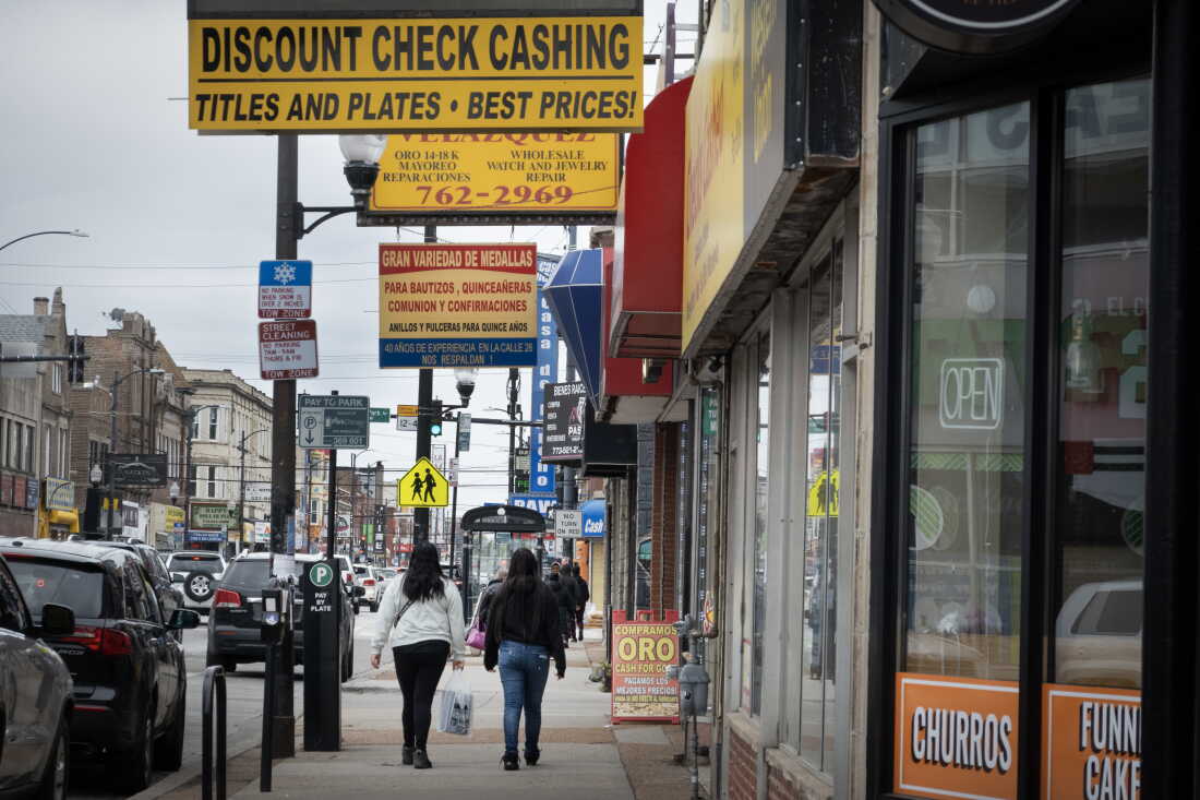 People walk along 26th Street, the heart of the commercial district in the Little Village neighborhood in Chicago, a neighborhood predominantly composed of Mexican immigrants.