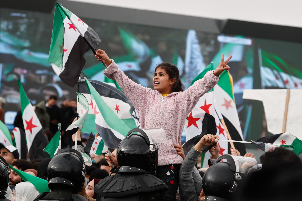 People wave the Syrian flag as they gather during celebrations marking the first anniversary of the ousting of former President Bashar al-Assad in Damascus, Syria, Monday.