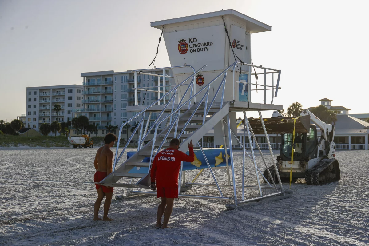 From left, Matthew Blowers and Patrick Brafford prepare to secure a lifeguard tower in preparation of potential storm at Clearwater Beach on Saturday, in Clearwater, Fla.