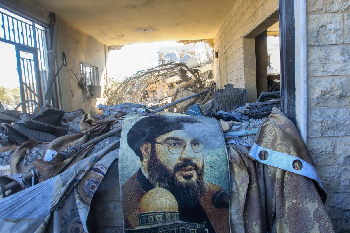 A portrait of Hezbollah chief Hassan Nasrallah sits amid destruction in an area targeted overnight by Israeli airstrikes in Saksakiyeh on Sept. 26.