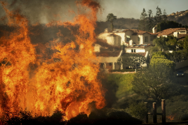 Flames rise as the Palisades Fire advances on homes in the Pacific Palisades neighborhood of Los Angeles.