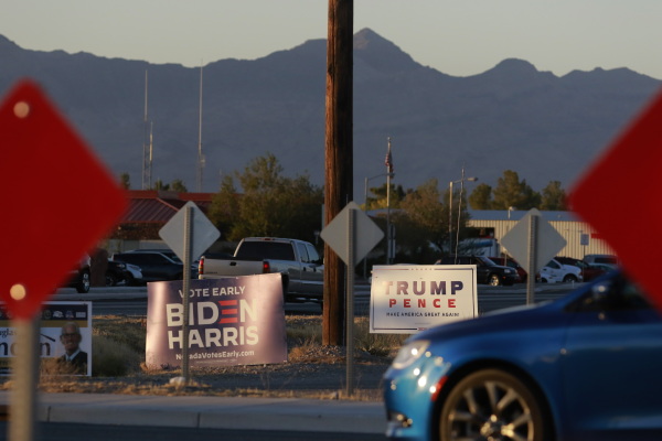 Campaign signs are shown at an intersection near a voting station on November 3, 2020, in Pahrump, Nevada. - Americans were voting on Tuesday under the shadow of a surging coronavirus pandemic to decide whether to reelect Republican Donald Trump, one of the most polarizing presidents in US history, or send Democrat Joe Biden to the White House. (Photo by Ronda Churchill / AFP) (Photo by RONDA CHURCHILL/AFP via Getty Images)