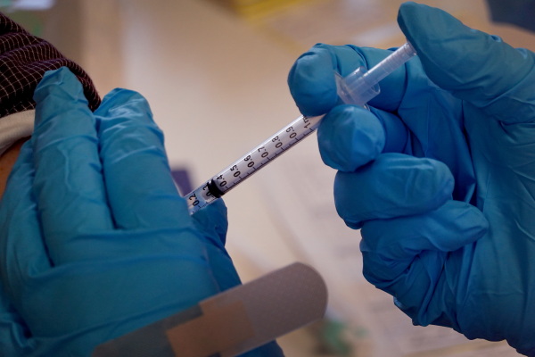 A pharmacist administers a COVID-19 vaccine.