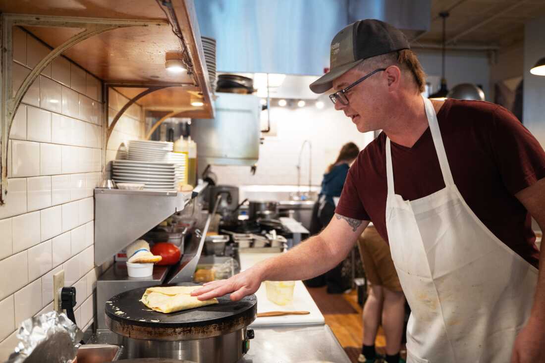 Michael Haskett makes crepes at the delicatessen he owns in the historical downtown area of Sioux Falls.