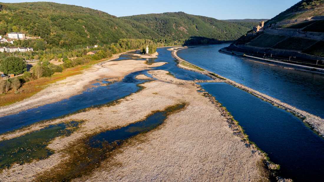 Picture taken on August 14, 2026 with a drone shows the "Binger Mäuseturm" (Bingen Mouse Tower) on a small island in the dried-up river Rhine near Bingen, western Germany. As a heat wave dries Germany's rivers, government ministers are at odds over what to do about it -- re-engineer the waterways or restore them to their natural state.