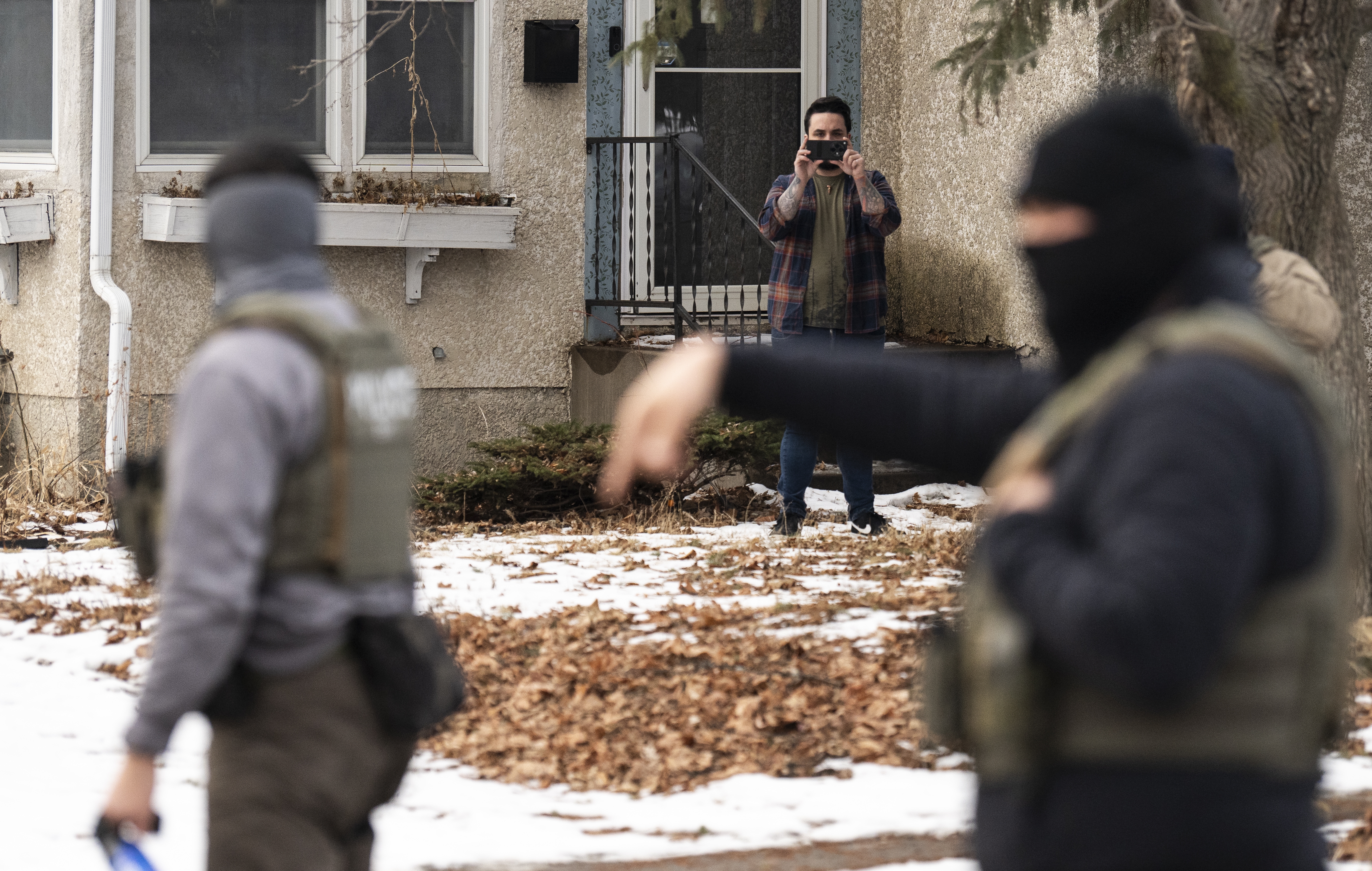 An observer films ICE agents this month in Minneapolis. A new lawsuit alleges federal agents are unconstitutionally retaliating against people who are lawfully observing and recording federal immigration enforcement operations by gathering their personal information and labeling them as domestic terrorists