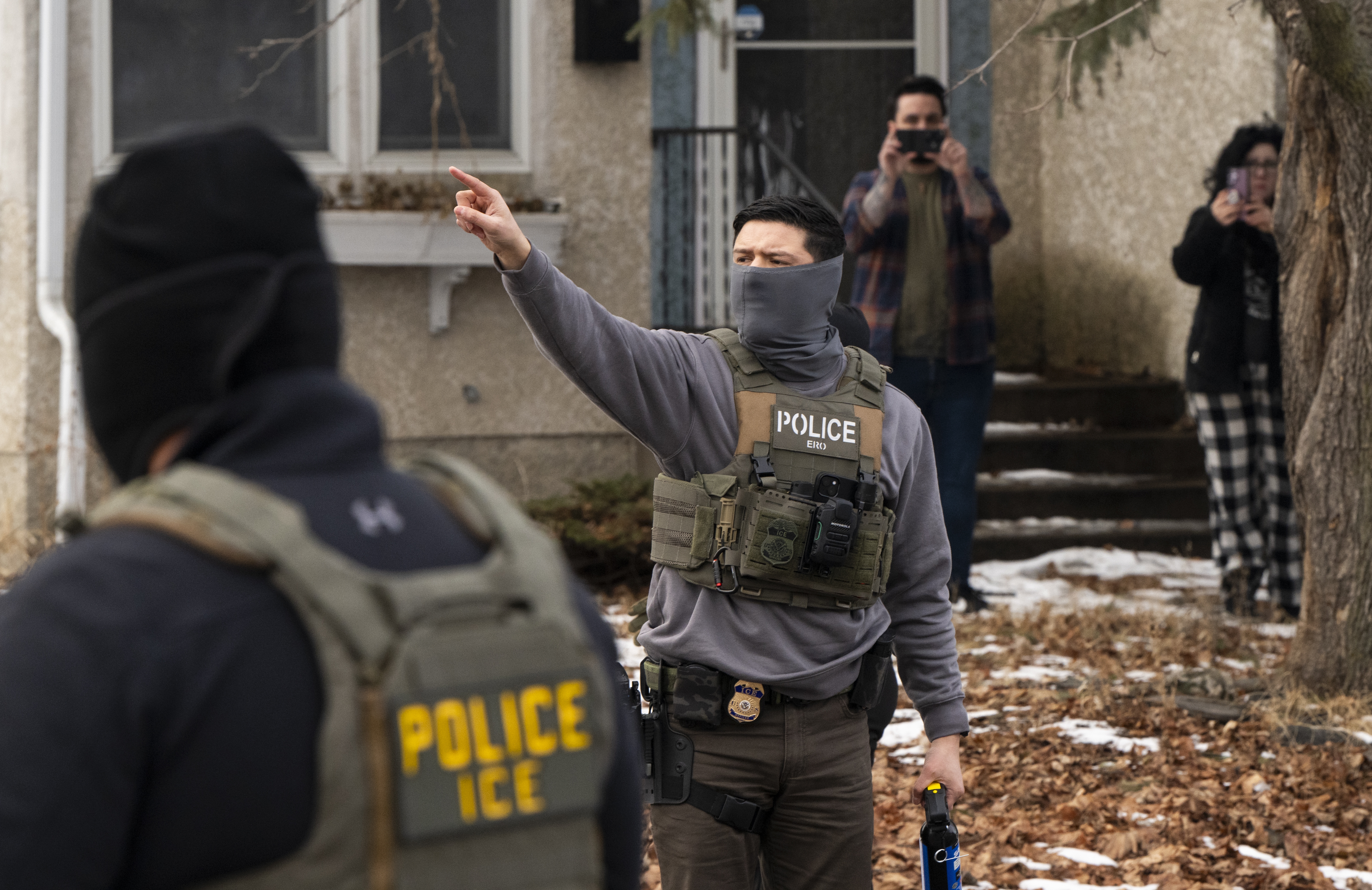 Observers film Immigration and Customs Enforcement agents as they hold a perimeter after one of their vehicles got a flat tire on Penn Avenue in Minneapolis on Feb. 5.