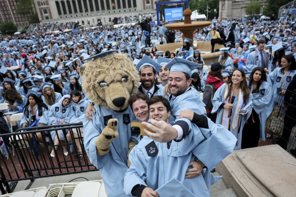 Students pose with a person dressed as Roar-ee the Lion mascot, before the Commencement Ceremony at Columbia University in New York on May 21.