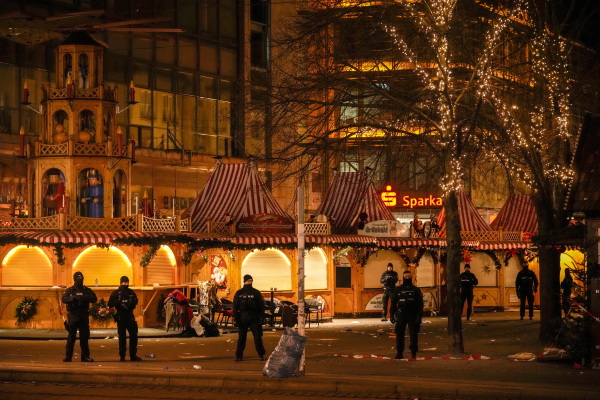 Security guards stand in front of a cordoned-off Christmas Market after a car crashed into a crowd of people, in Magdeburg, Germany, Saturday early morning, Dec. 21, 2024.