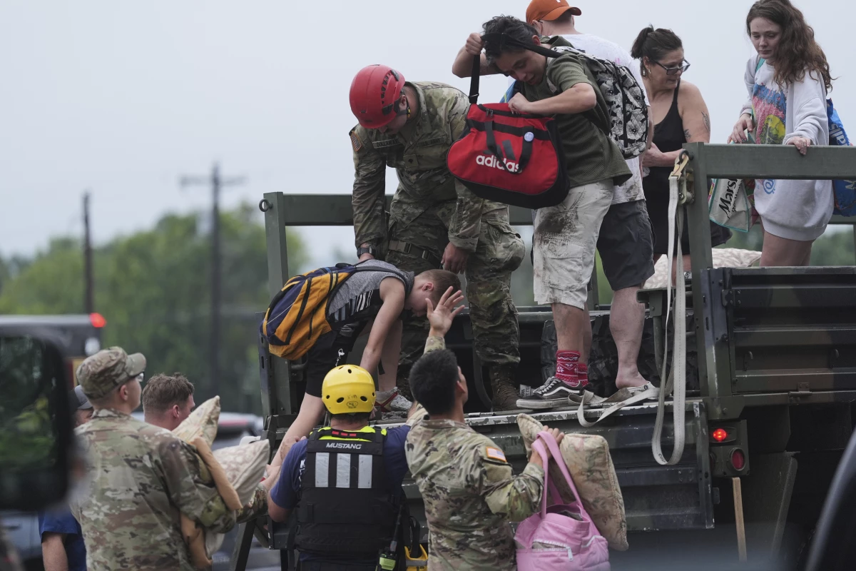 First responders deliver people to a reunification center after flash flooding in the area in Ingram, Texas.
