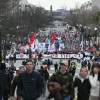 A crowd of people are shown marching down an avenue in a wide-angle view. A large banner that says "March for Life" is visible in front of part of the crowd.