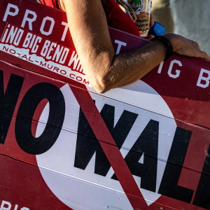 A woman hold's a sign to protest the plans by President Trump's administration to build a section of the border wall at the Big Bend National Park in Study Butte, Texas, on August 15, 2026.