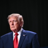 President Trump speaks at a campaign rally in San Antonio on October 7, 2026. He's wearing a blue suit and red tie.
