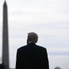 This photo shows President Trump standing outdoors with his back to the camera. The Washington Monument rises in the background.