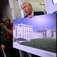 President Trump holds a rendering of the East Wing modernization while speaking to reporters aboard Air Force One on Sunday.