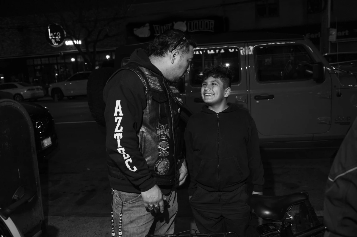 Sergio Garcia, known as 'Toluco,' jokes with his son outside of 'Mama Puebla,' a Mexican restaurant in the Bronx owned by one of the Aztec Rebels.