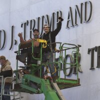 Workers react to the media after updating signage outside the Kennedy Center on Dec. 19, 2025, in Washington, D.C.