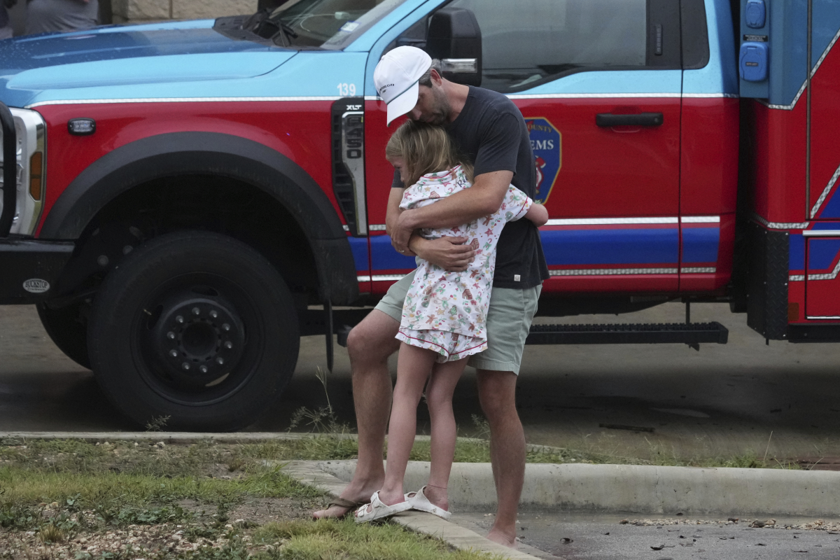People are reunited Friday at a reunification center in Ingram, Texas, after flash flooding hit the area.