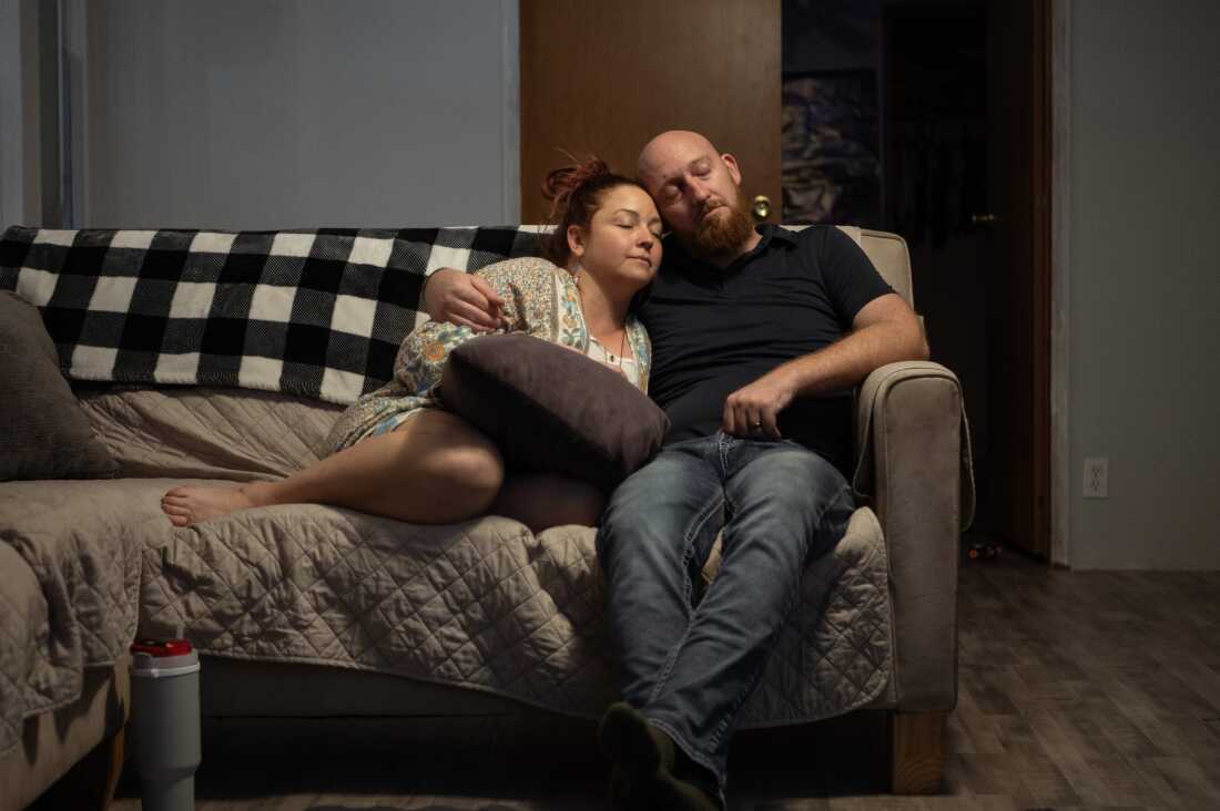 Erica and Wade Hanicker rest together on the couch after putting their two children to bed. Wade Hanicker says one of the hardest things about living with silicosis is "not being able to be a father the way I want to with my kids."