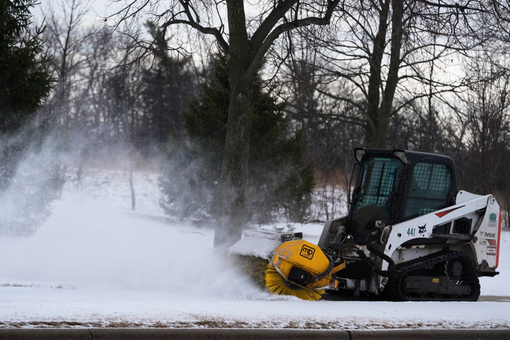 A plow clears snow from a snow-covered sidewalk during a cold day in Lake Forest, Ill., Wednesday, Jan. 21, 2026. (AP)