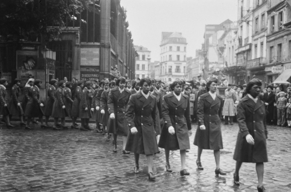 A black and white photo of Black female soldiers walking in a parade.