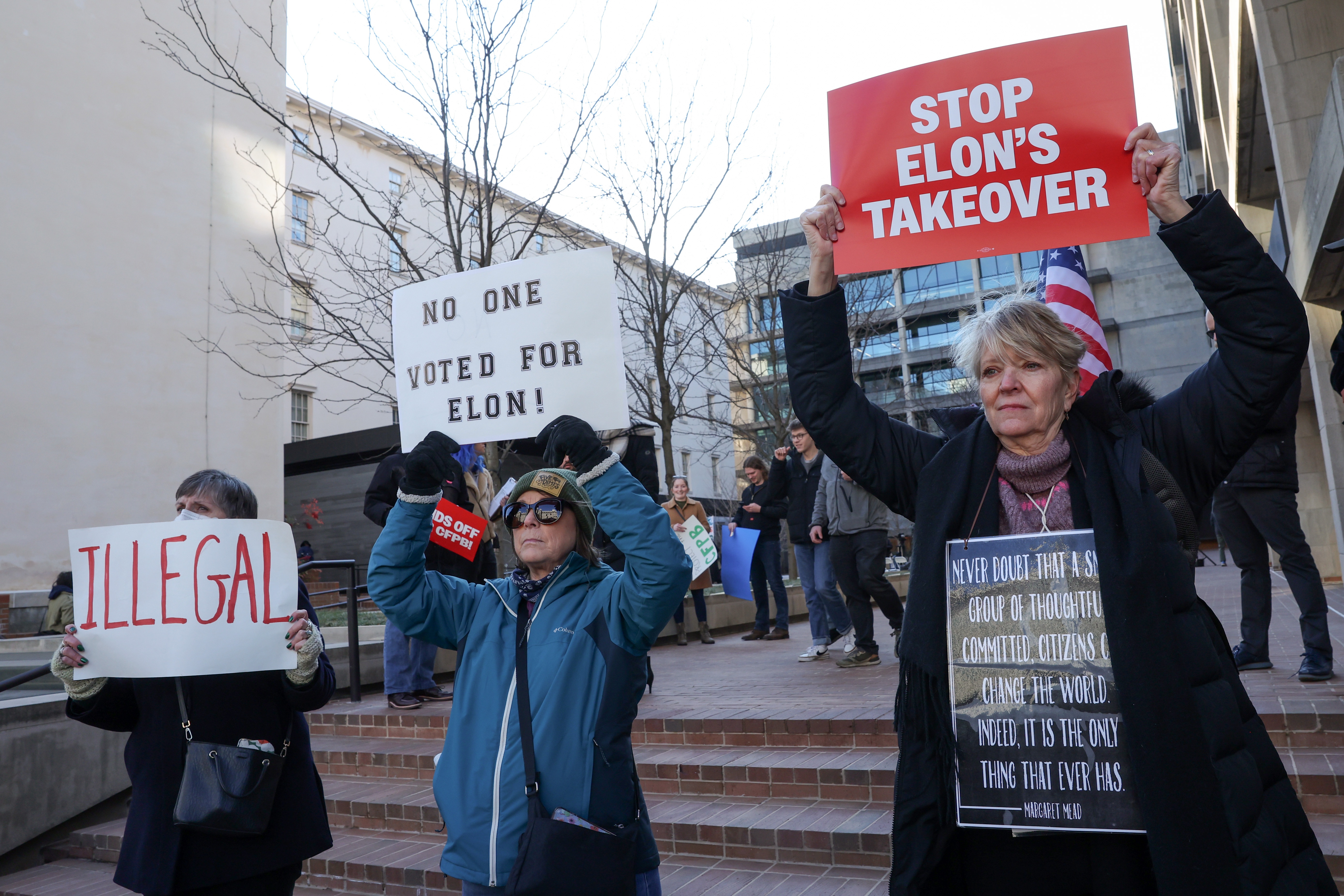 Demonstrators raise signs at a rally to protest the closing of the Consumer Financial Protection Bureau last month in Washington, D.C.
