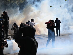 Protesters scuffle with police during a demonstration against rising living costs, joining students' grievances, in Paris on Saturday.